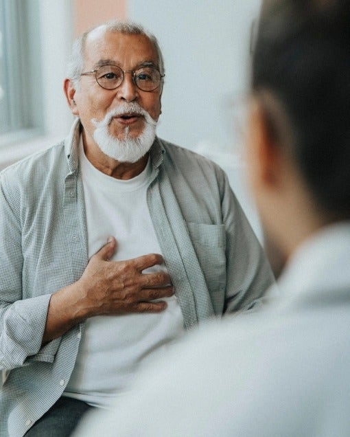 Un señor mayor con una barba está hablando con su doctor sobre la diabetes y el COVID-19.