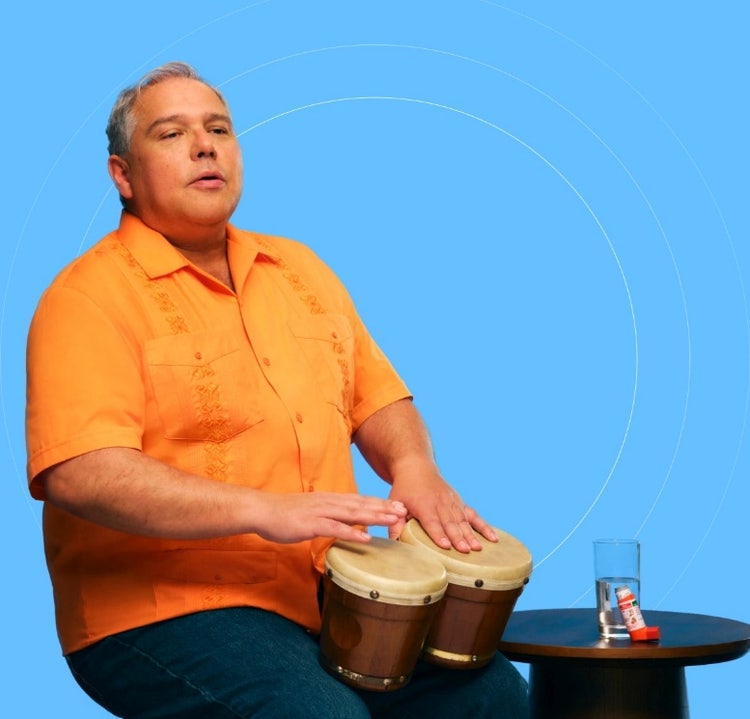 Foto de un hombre Latino que tiene COVID-19 factores de alto riesgo tocando bogos.