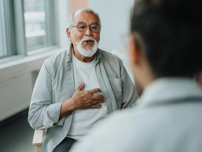 Un señor mayor con una barba está hablando con su doctor sobre la diabetes y el COVID-19.